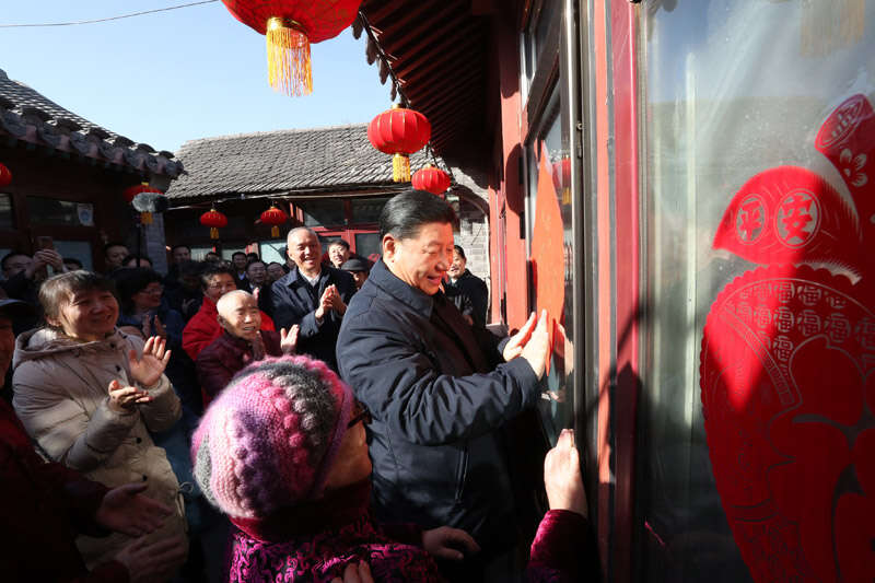 2019年2月1日上午，習(xí)近平在北京前門東區(qū)草廠四條胡同32號院，高興地拿起一幅“?！弊?，親自貼到門上，給這里的老街坊們拜年。新華社記者 鞠鵬 攝